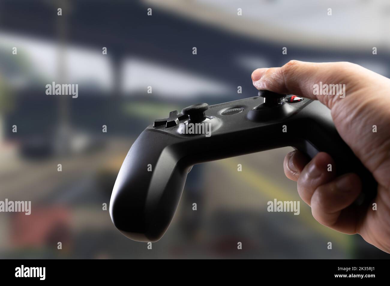 GAM22ICB Gamepad in der Hand einer Person, die ein aufregendes Videospiel spielt. Cyberspace, eSports, neue drahtlose Technologien, Online-Spiele mit Freunden, Co Stockfoto