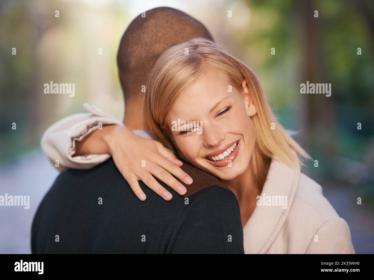 Glück ist die Begegnung mit einem alten Freund. Ein junges Paar umarmt sich im Freien. Stockfoto