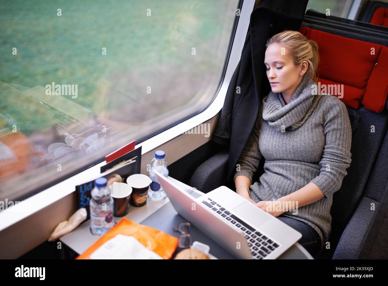 So viel Platz zum Entspannen. Eine attraktive junge Frau, die mit dem Zug unterwegs ist. Stockfoto