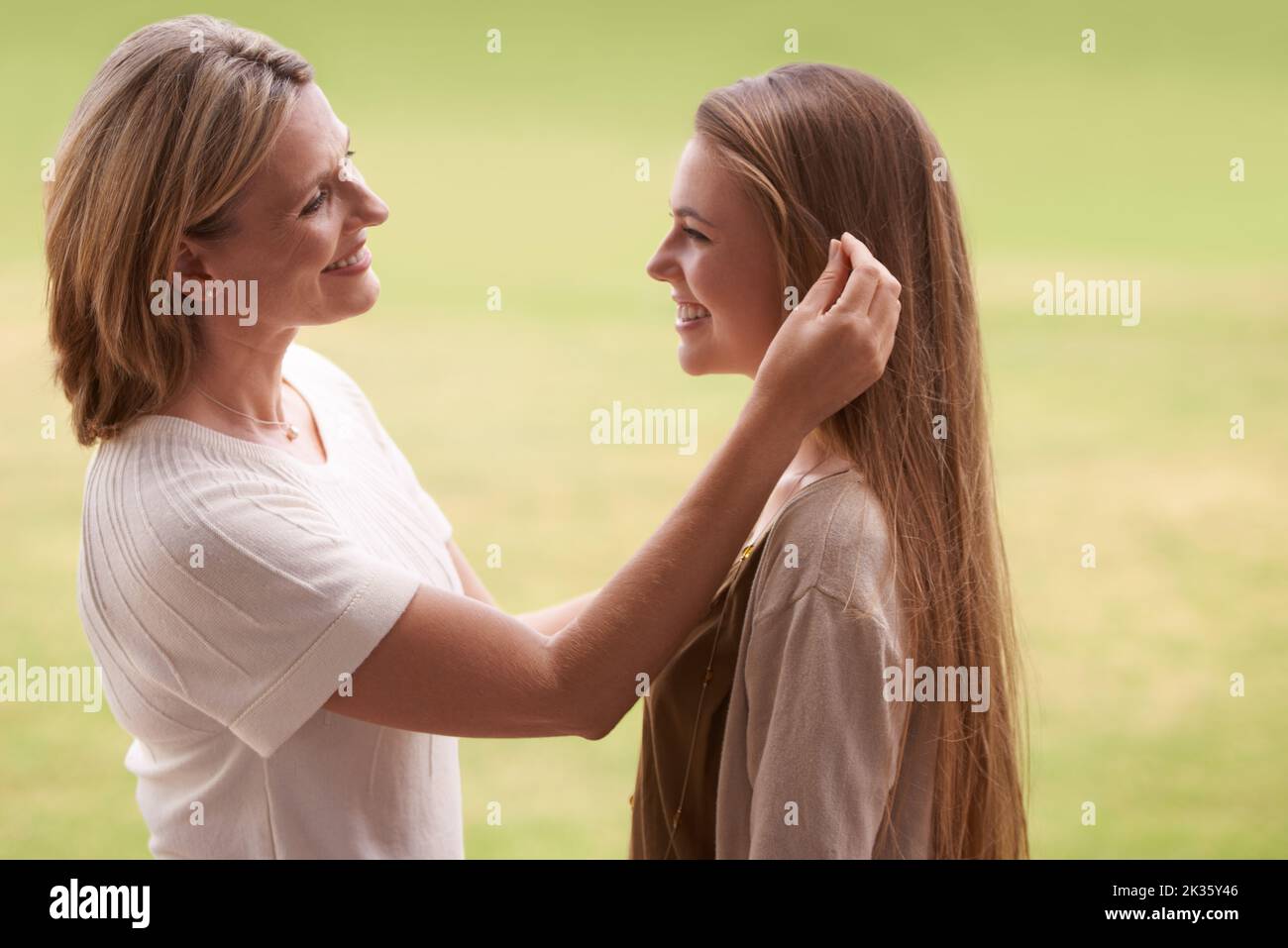Ihr seid mir so wichtig. Eine Mutter streichelt die Haare ihrer Töchter. Stockfoto