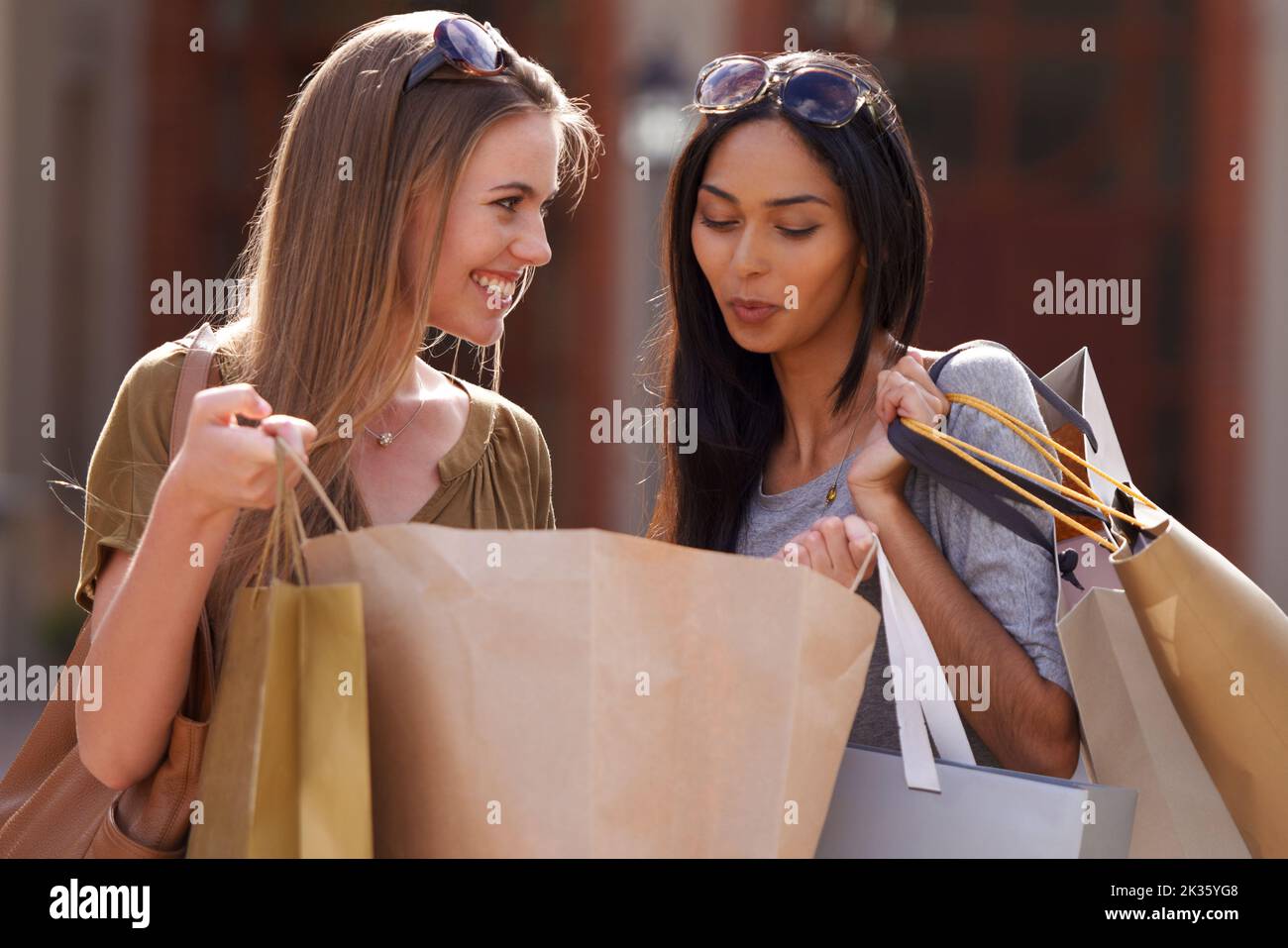 Sie freuen sich auf das gemeinsame Einkaufen. Zwei attraktive junge Frau mit ihren Einkaufstaschen nach einem Tag der Verkaufstherapie. Stockfoto