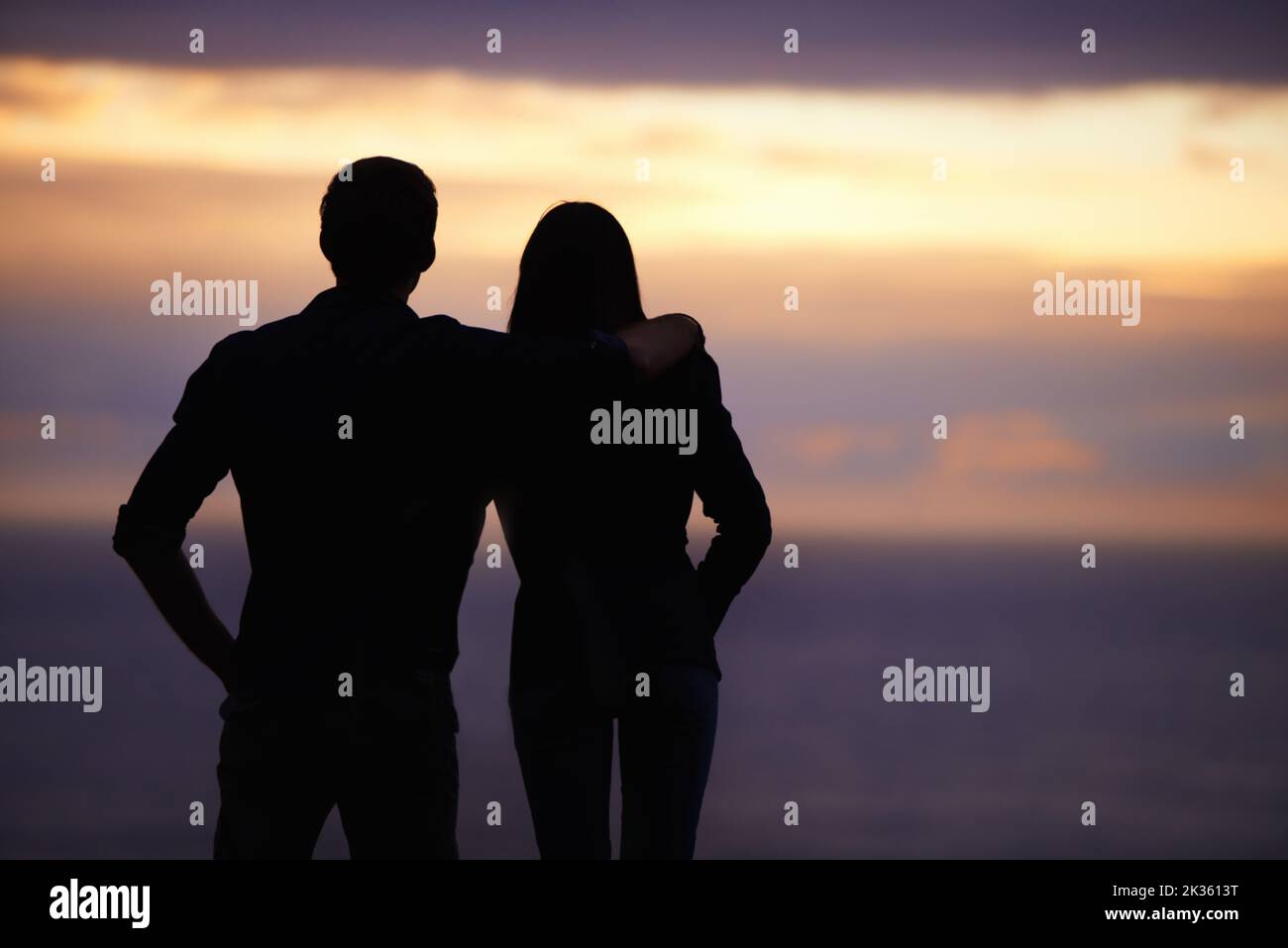 Bewundern Sie die Schönheit des Sonnenuntergangs - Seite an Seite. Zwei Personen mit Blick auf den Sonnenuntergang. Stockfoto
