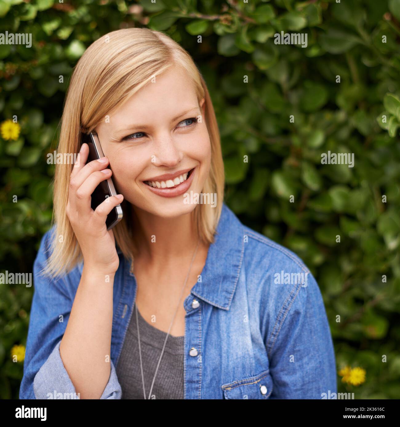 Treffen wir uns im Park. Eine attraktive Frau, die im Park telefoniert. Stockfoto