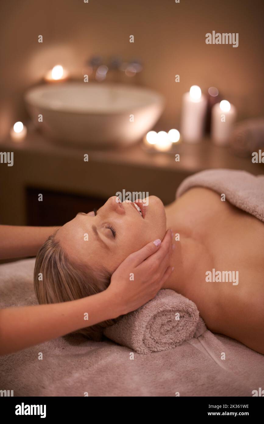 Genießen Sie eine Kopf- und Nackenmassage. Eine Frau in einem Day Spa bekommt eine Gesichtsmassage. Stockfoto