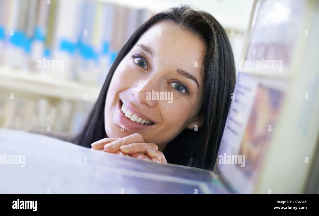 Wer sagt, man kann kein Datum in einer Bibliothek abholen. Porträt einer jungen Studentin in einer Bibliothek. Stockfoto