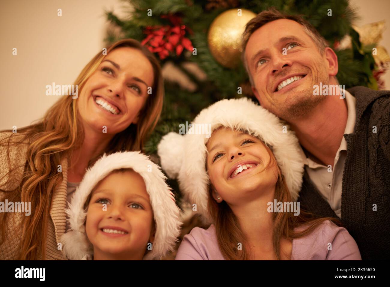 Gefüllt mit festlichen Tagträumen. Eine glückliche junge Familie am Weihnachtstag. Stockfoto