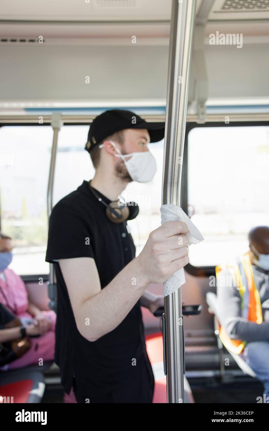 Männlich teen Arbeiter mit Schutztuch und Gesichtsmaske Reiten Bus Stockfoto