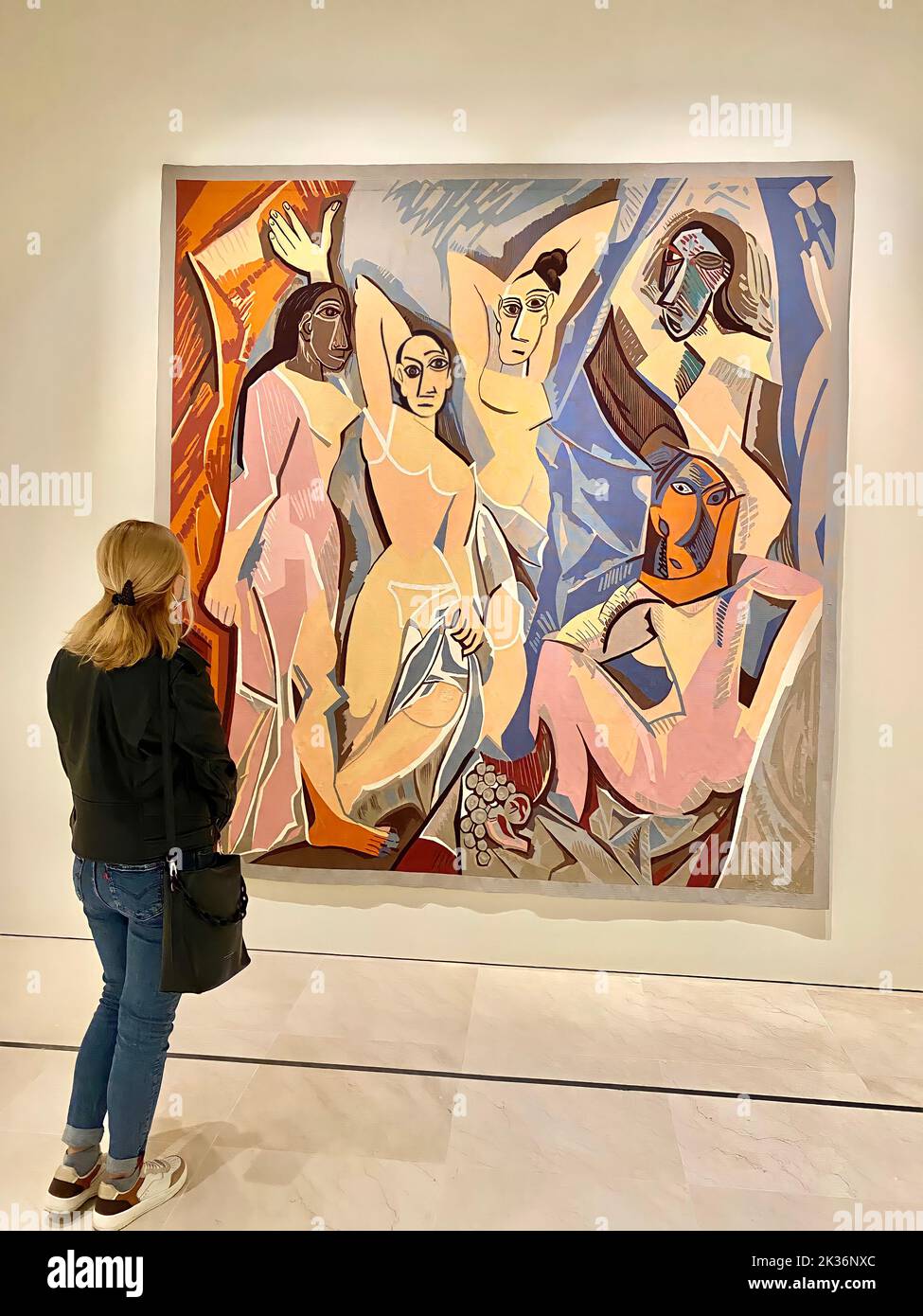 30.10.2021. Malaga, Spanien. Blondes Mädchen, das vor Pablo Picassos einem der berühmtesten Gemälde namens Les Demoiselles dAvignon im Picasso-Musseum in Malaga steht. Hochwertige Fotos Stockfoto