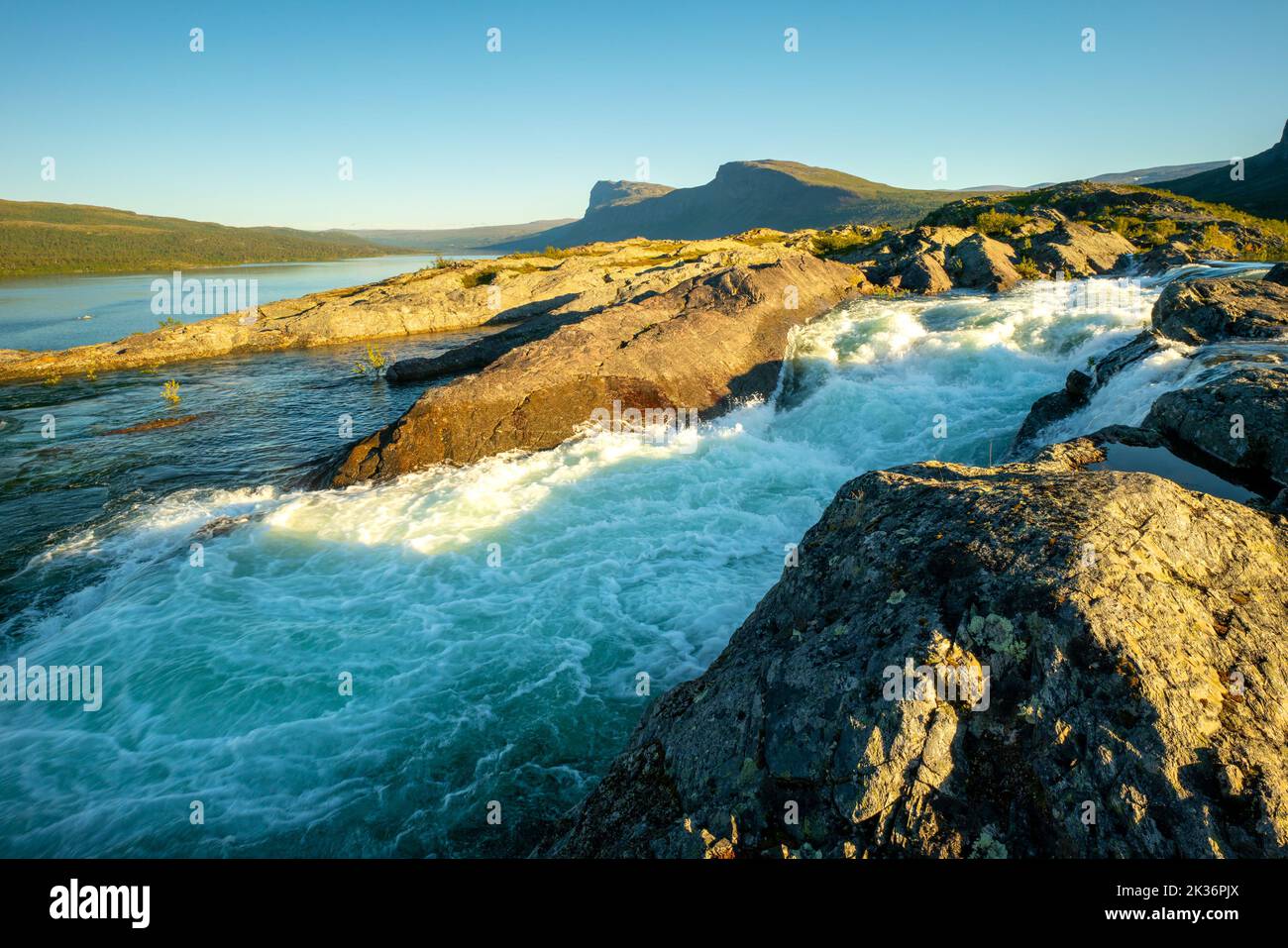 Goldene Stunde bei den Stromschnellen des Stuor Muorkke Wasserfalls im Stora Sjofallet Nationalpark, Schweden. Abenteuer in arktischer Wildnis. Schöner sonniger Tag in Stockfoto