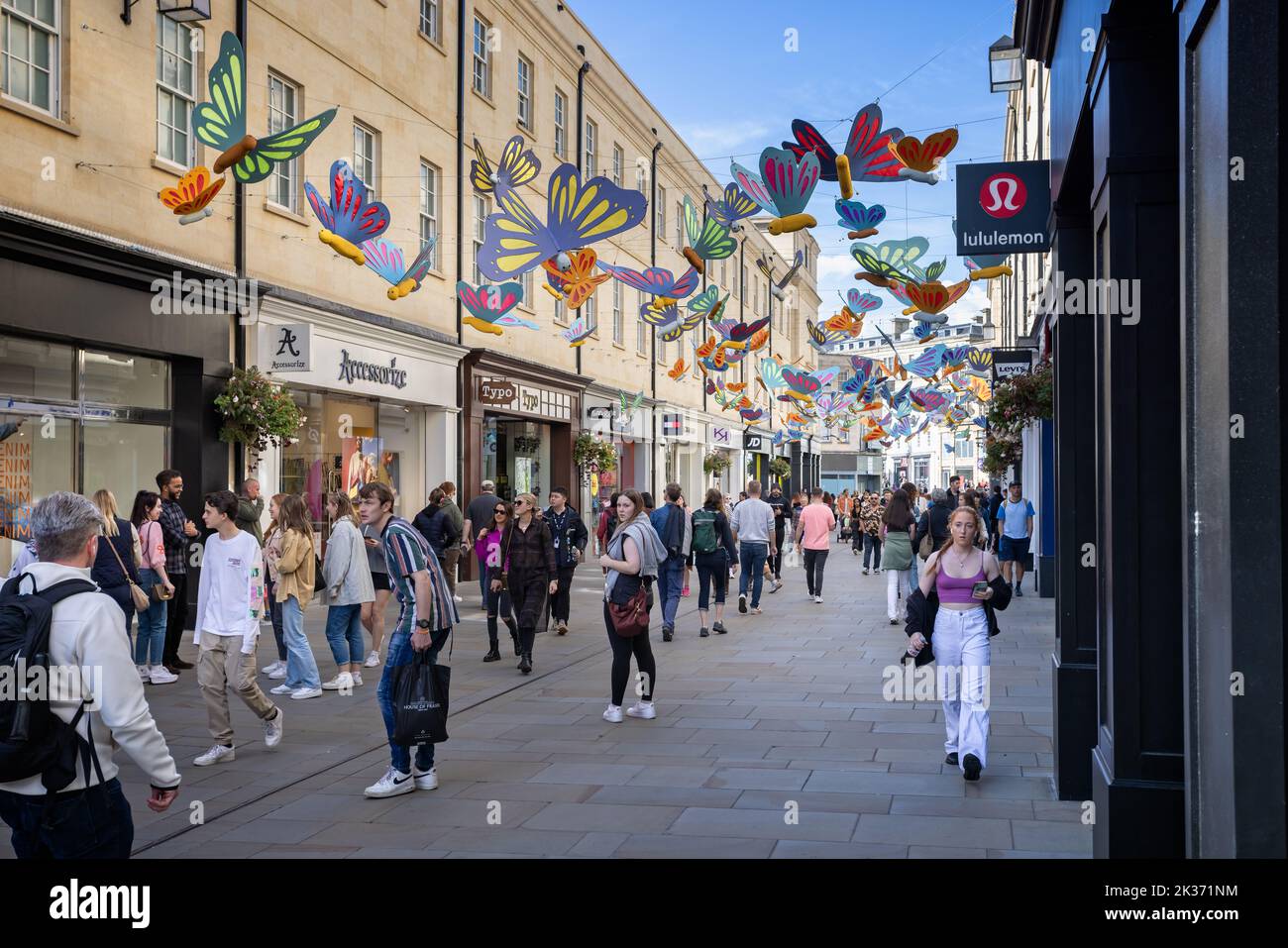 Shopper, die am 24. september 2022 im Southgate Shopping Centre in Bath, Avon, Großbritannien, unter einem Baldachin von bunten Schmetterlingen spazieren Stockfoto