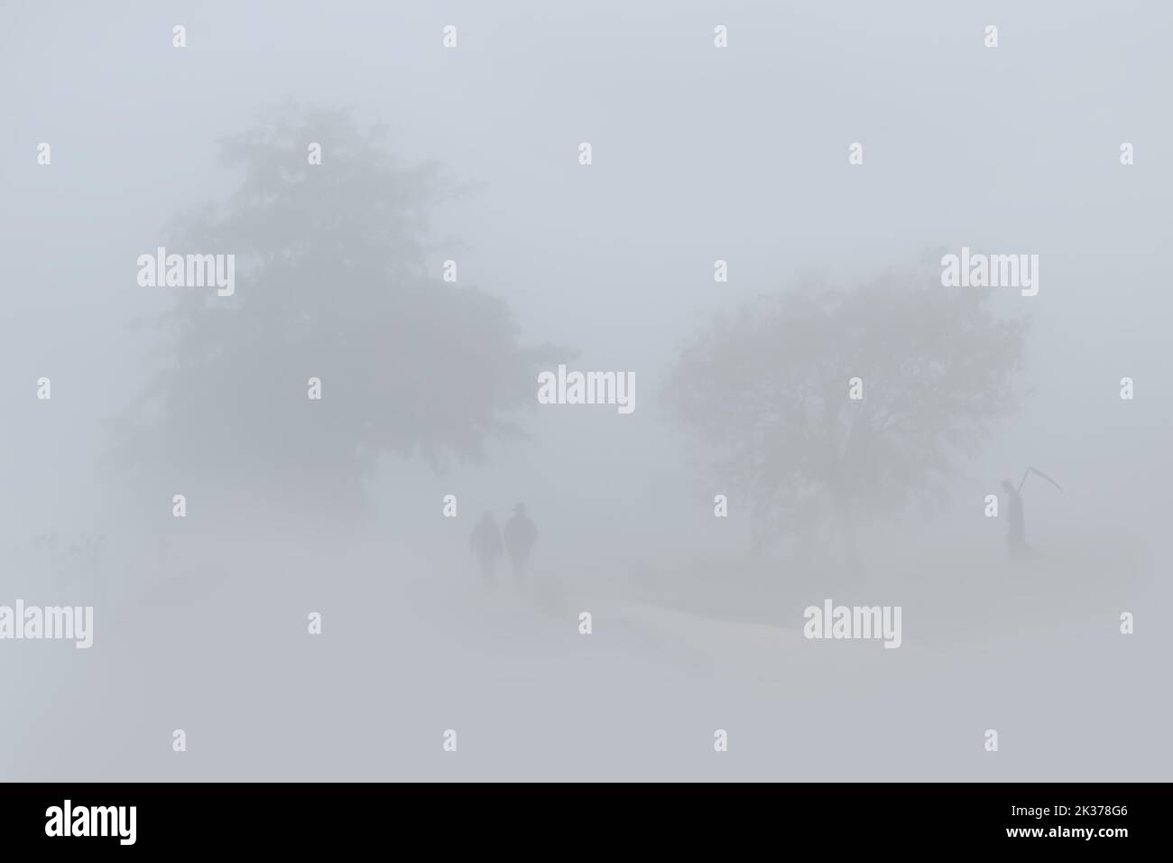 Der grimmige Schnitter im Nebel wartet auf das alte Paar Stockfoto