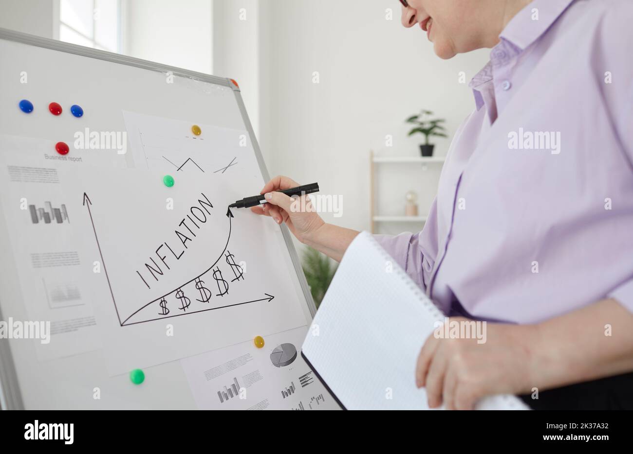 Wortinflation, geschrieben von einer Geschäftsfrau auf dem Whiteboard während der Präsentation im Büro. Stockfoto