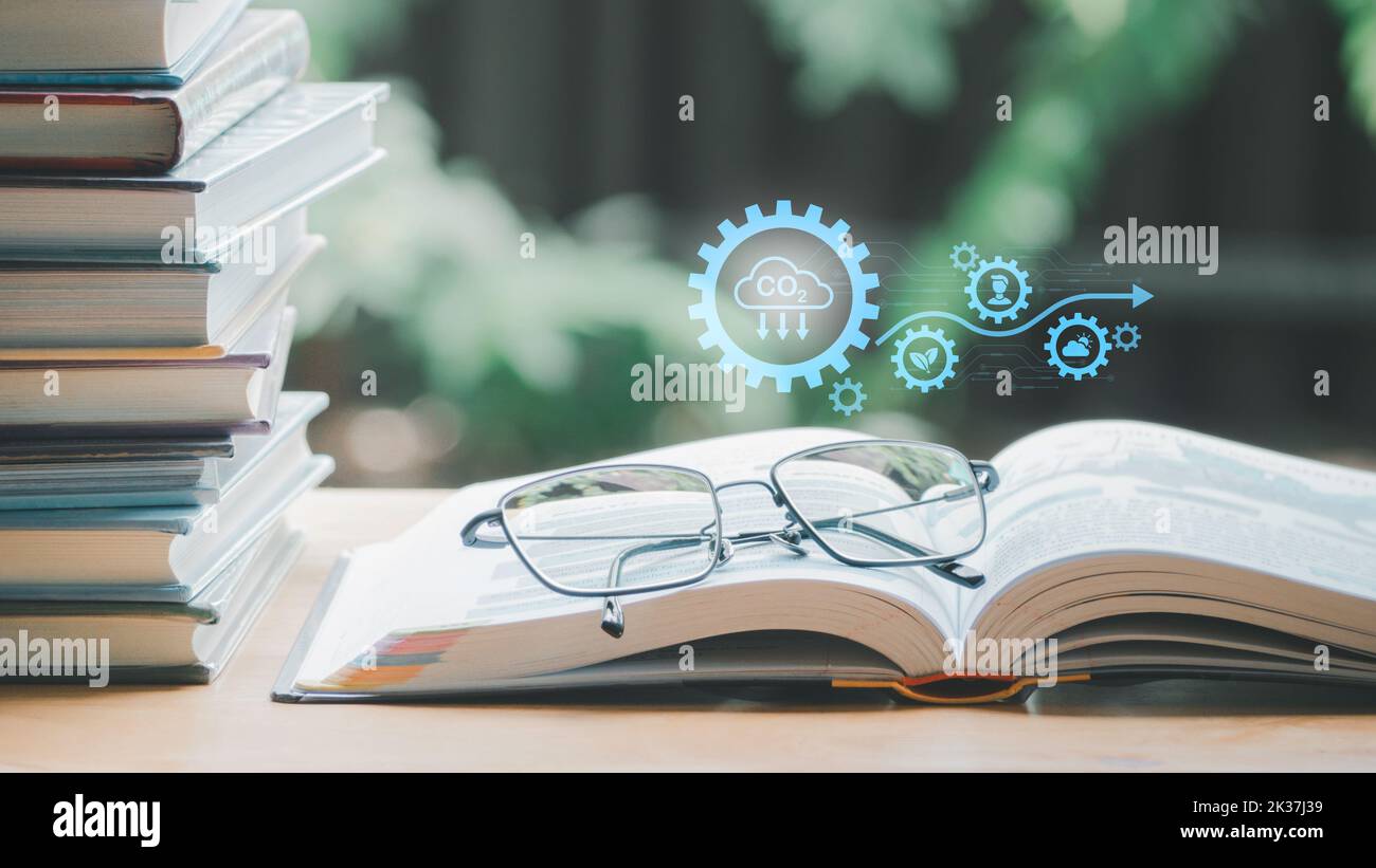 Eine einfache Zusammenstellung von vielen Büchern, Stapel oder Stapel von Büchern auf Holztisch, einer von ihnen öffnen und Gläser mit Ikonen sparen CO2 und Energiequellen für RE Stockfoto