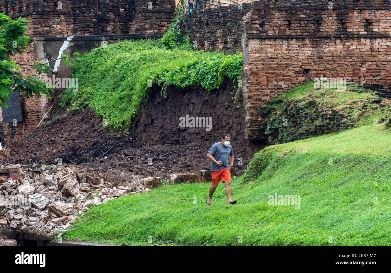 Ein Mann sah, wie er am Chang Phuak-Tor im Bezirk Muang in Chiang Mai vorbei an der Mauer ging, die durch starken Regen zusammenbrach. Die alte Stadtmauer von Chiang Mai, in der Nähe des Chang Phuak-Tores, stürzte gestern Abend aufgrund des starken Regens teilweise ein, was Beamte des Fine Arts Department und der Gemeinde Chiang Mai dazu veranlasste, den Schaden vor Beginn der Renovierungsarbeiten zu beurteilen. (Foto von Pongmanat Tasiri / SOPA Images/Sipa USA) Stockfoto