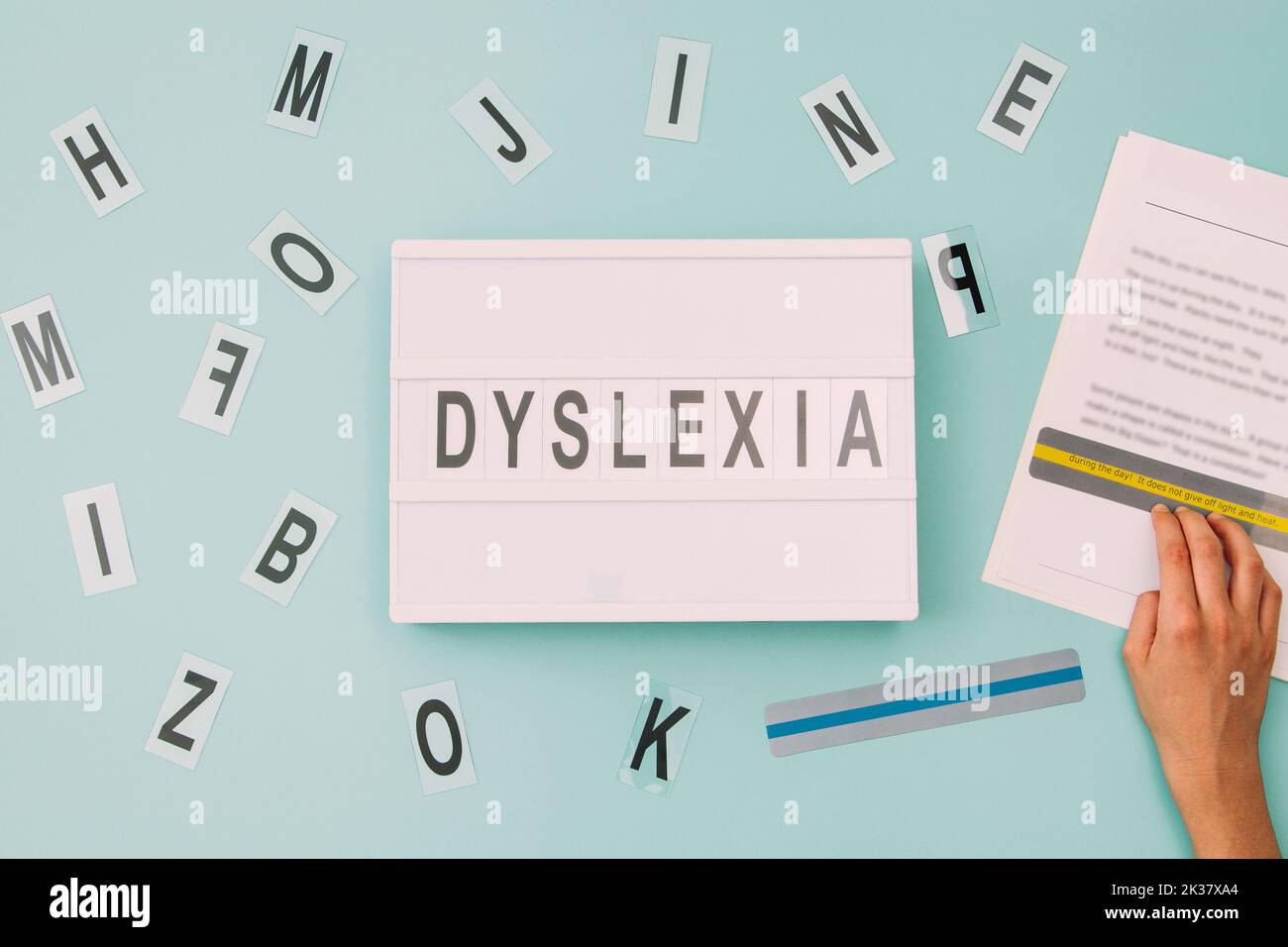 Dyslexie Bewusstsein, helfen Kindern beim Lesen, Lernschwierigkeiten Konzept. Kinder lesen Text mit farbigen Linealen überlagert Streifen. Leuchtkasten mit Stockfoto