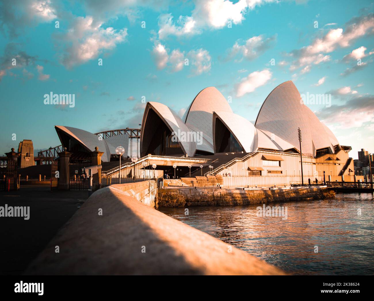 Das berühmte Opernhaus von Sydney im warmen Licht des Sonnenaufgangs mit weißen Wolken am Himmel in Sydney, New South Wales, Australien Stockfoto