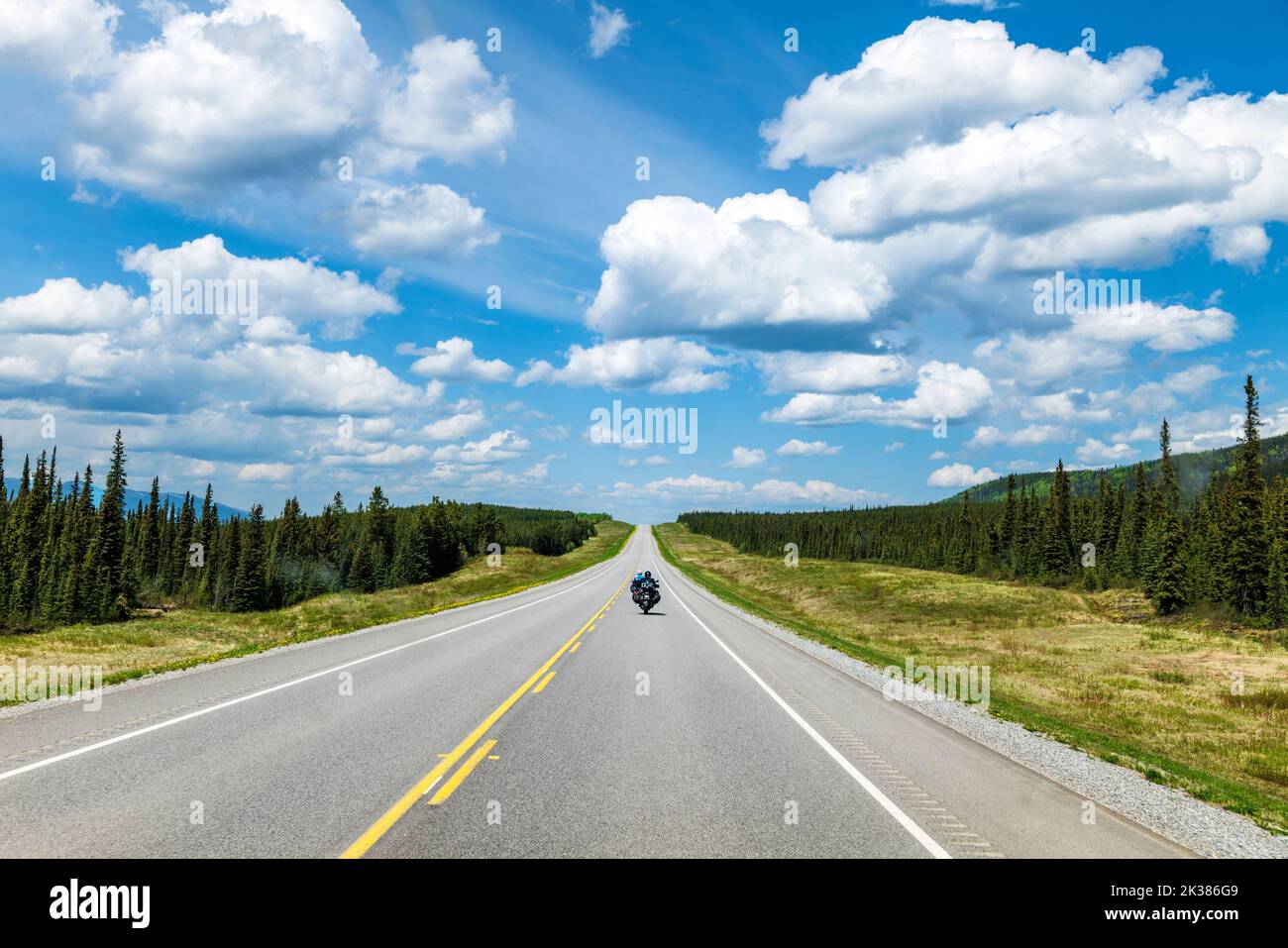 An einem schönen Sommertag fahren zwei Motorradfahrer auf dem Alaska Highway in der Nähe des Propheten River; British Columbia; Kanada Stockfoto