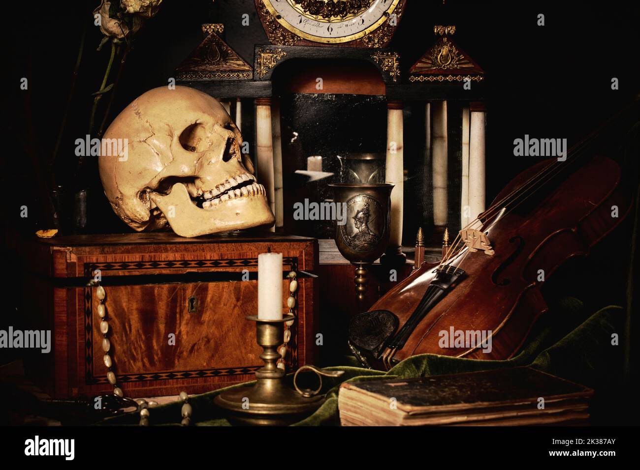 Nahaufnahme Stillleben, holländische Malerei des 17.. Jahrhunderts. Auf dem Tisch auf schwarzem Hintergrund sind Blumen, ein Totenkopf, eine Uhr, eine Geige, Schlüssel. Dinge, die Stockfoto