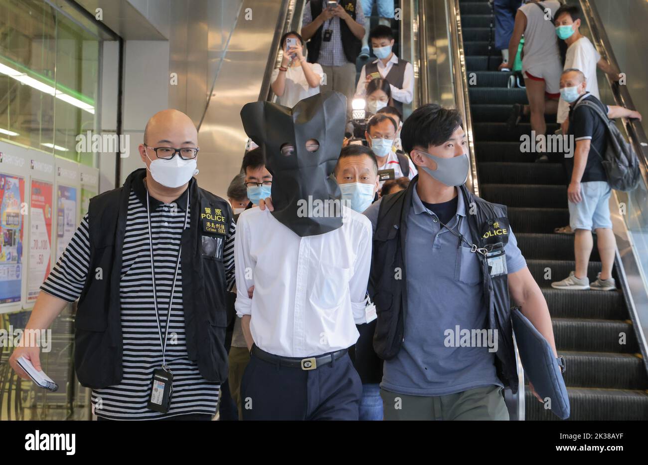 Polizisten eskortieren einen Verdächtigen aus der Klinik von Doktor Wong Ping-leung in hing Wah Plaza, Chai Wan. Dr. Wong von Chai Wan, Dr. Charlie Yan kam-Sun von Yuen Long und Dr. Amy Lam Ding-yee von Tin Shui Wai wurden verhaftet, weil sie illegal Covid-19-Impfgenehmigungen ausgestellt hatten. 22SEP22 Jelly Tse/SCMP Stockfoto