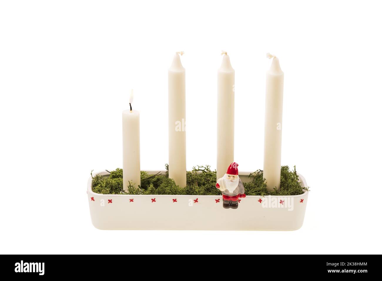 Ansicht des traditionellen Kerzenständers gefüllt mit Moos mit brennendem Kerzenschein zu Ehren des ersten Kommens auf weißem Hintergrund. Schweden. Stockfoto