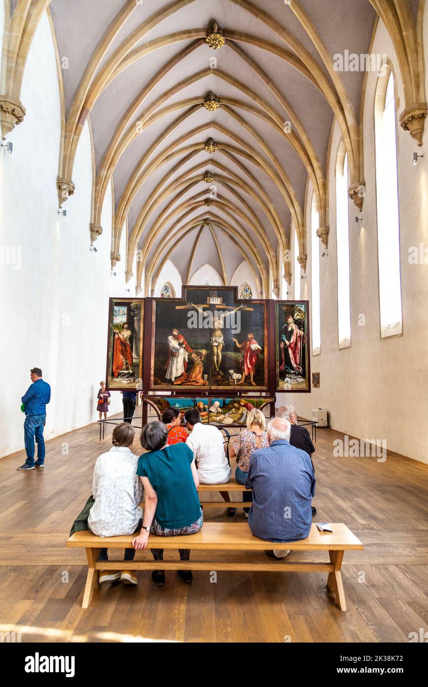 Besucher sehen den Isenheimer Altar von Matthias Grünewald in der Kapelle des Unterlinden Museums, Colmar, Frankreich Stockfoto