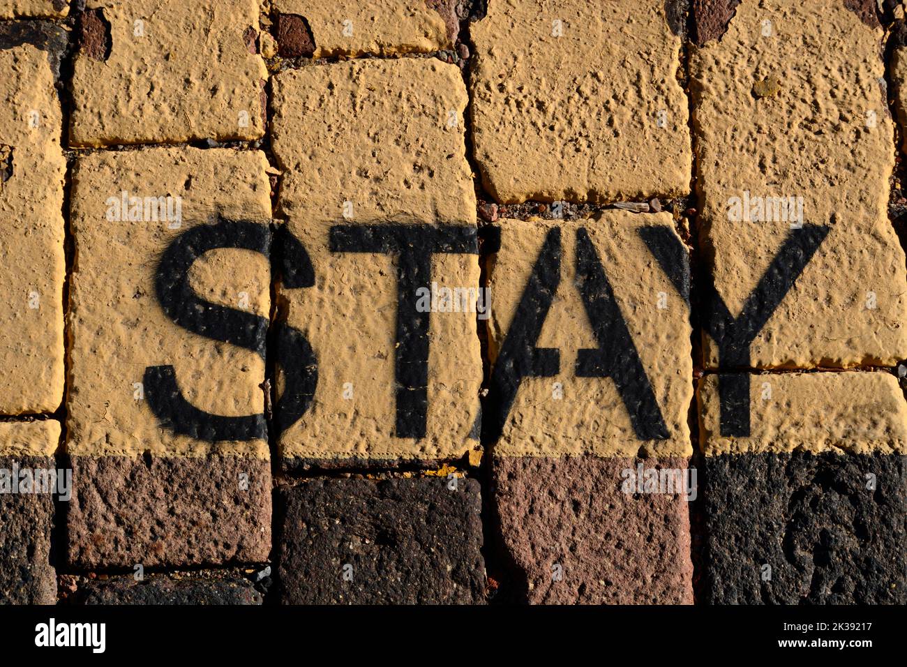 Das Wort 'Stay'-Schablone, gemalt auf einem Bürgersteig in Santa Fe, New Mexico. Stockfoto