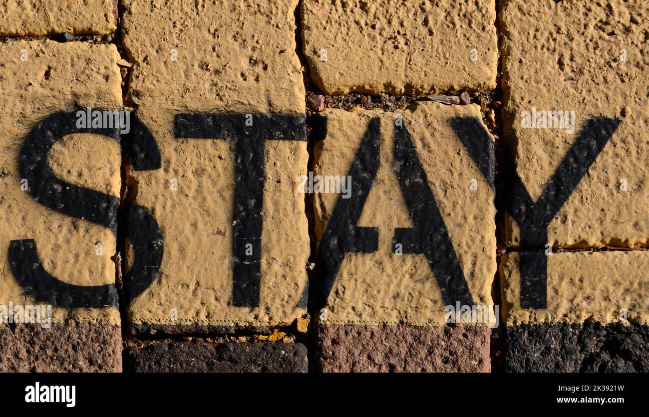 Das Wort 'Stay'-Schablone, gemalt auf einem Bürgersteig in Santa Fe, New Mexico. Stockfoto