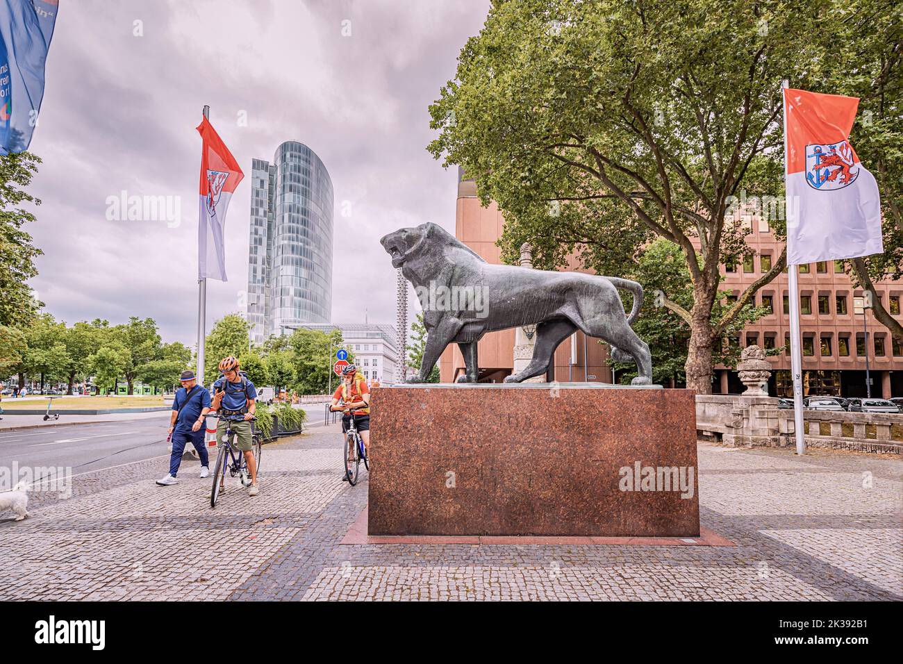 21. Juli 2022, Düsseldorf, Deutschland: Touristen Radfahrer an der Statue des Löwen - das Symbol und Wappen von Düsseldorf in der Nähe der königlichen Gasse und ca. Stockfoto