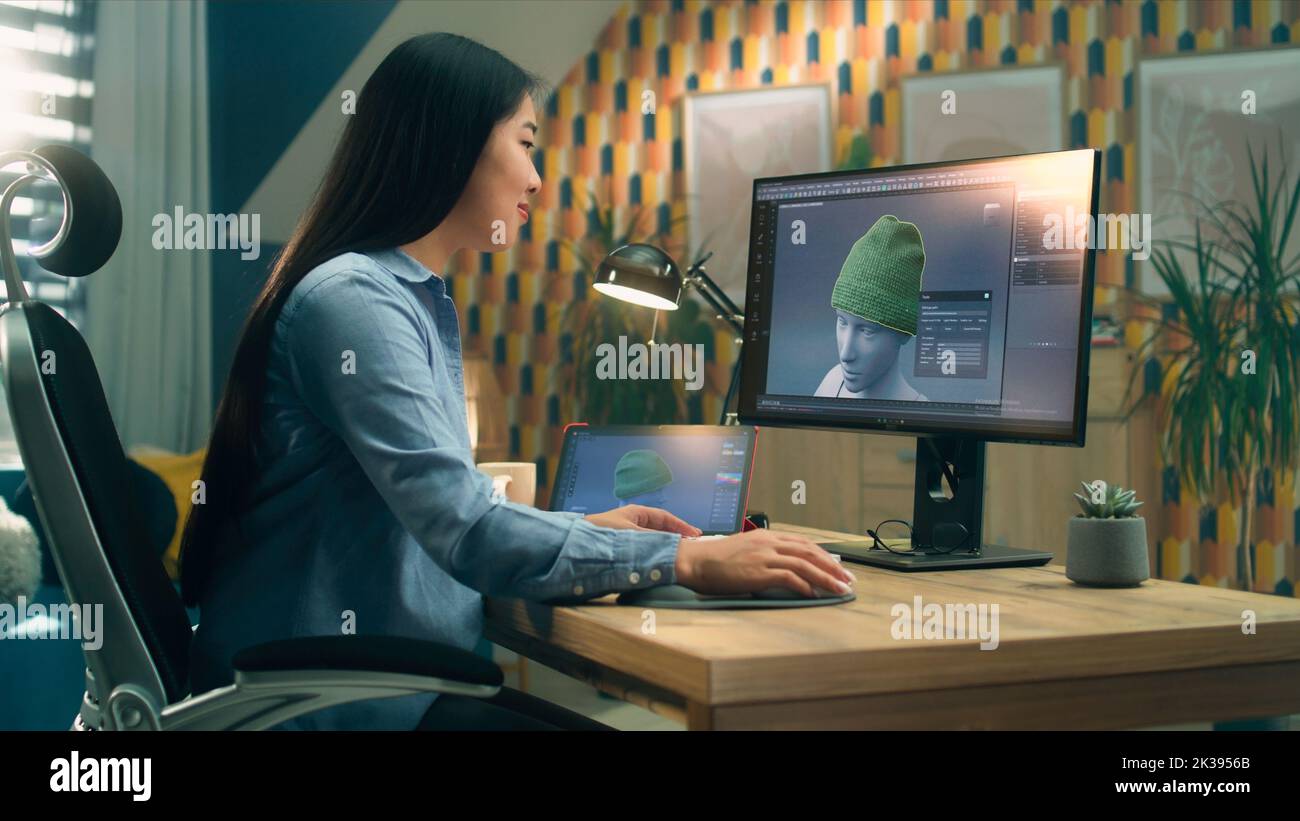 Weibliche asiatische 3D Designerin mit Remote-Arbeit an 3D Modellierung und Erstellung von 3D Visualisierung von Kleidung mit pc mit professioneller Software und Tablet-Computer Stockfoto