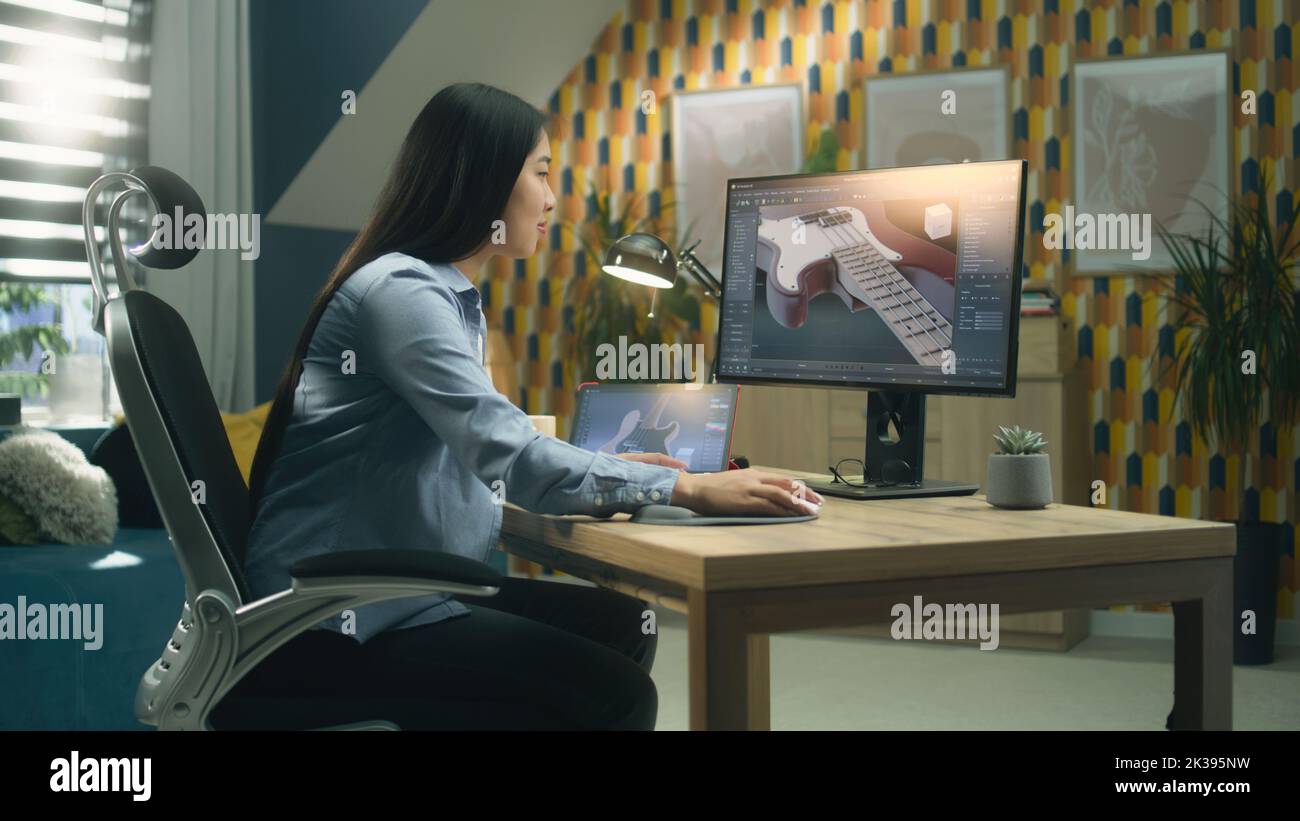 Weibliche asiatische 3D Designerin Erstellen 3D Modell der E-Gitarre und Herstellung von Grafik, mit Software für die Modellierung 3D Projekte während der Arbeit an pc und Tablet zu Hause. Stockfoto