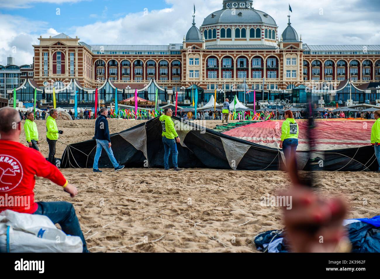 Das Holland Kite Team wird dabei gesehen, wie es sich auf einen der größten Drachen der Welt vorbereitet. Das International Kite Festival Scheveningen macht das Beste aus den konstant vorherrschenden Winden, die entlang des Strandresorts von Den Haag wehen. Drachenbauer und Enthusiasten aus der ganzen Welt kommen zusammen, um die Früchte ihrer kreativen Arbeit zu fliegen. Fast am Ende der Veranstaltung flog das Holland Kite Team ihren großen Drachen, der 1997 offiziell den Guinness-Weltrekord beim Bristol International Kite Festival erhielt. Die jährliche Veranstaltung sieht den Himmel über dem südlichen Teil des Strandes von Scheveningen gefüllt Stockfoto