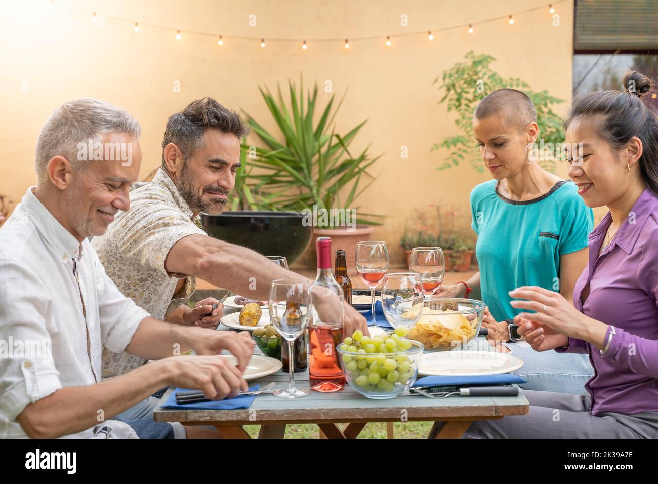 Multirassische Freunde, die am Tisch lachen. Gemeinsam genießen das Lebenskonzept. Stockfoto