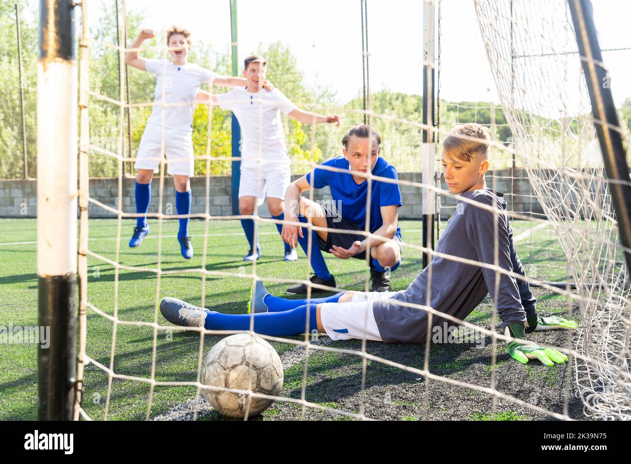 Verstörter Torwart schaut den Ball im Tor an. Fußballturnier Stockfoto