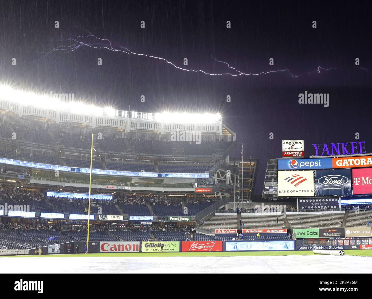 Bronx, Usa. 25. September 2022. Eine Lichtschraube erscheint hinter dem Yankee Stadium während einer Regenverzögerung, als die Boston Red Sox am Sonntag, den 25. September 2022, die New York Yankees im Yankee Stadium in New York City spielen. Foto von John Angelillo/UPI Credit: UPI/Alamy Live News Stockfoto