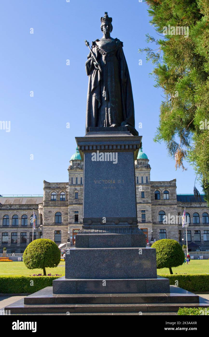 Eine Statue der Königin Victoria vor den Parlamentsgebäuden von British Columbia (hinten gesehen) in Victoria, British Columbia, Kanada Stockfoto
