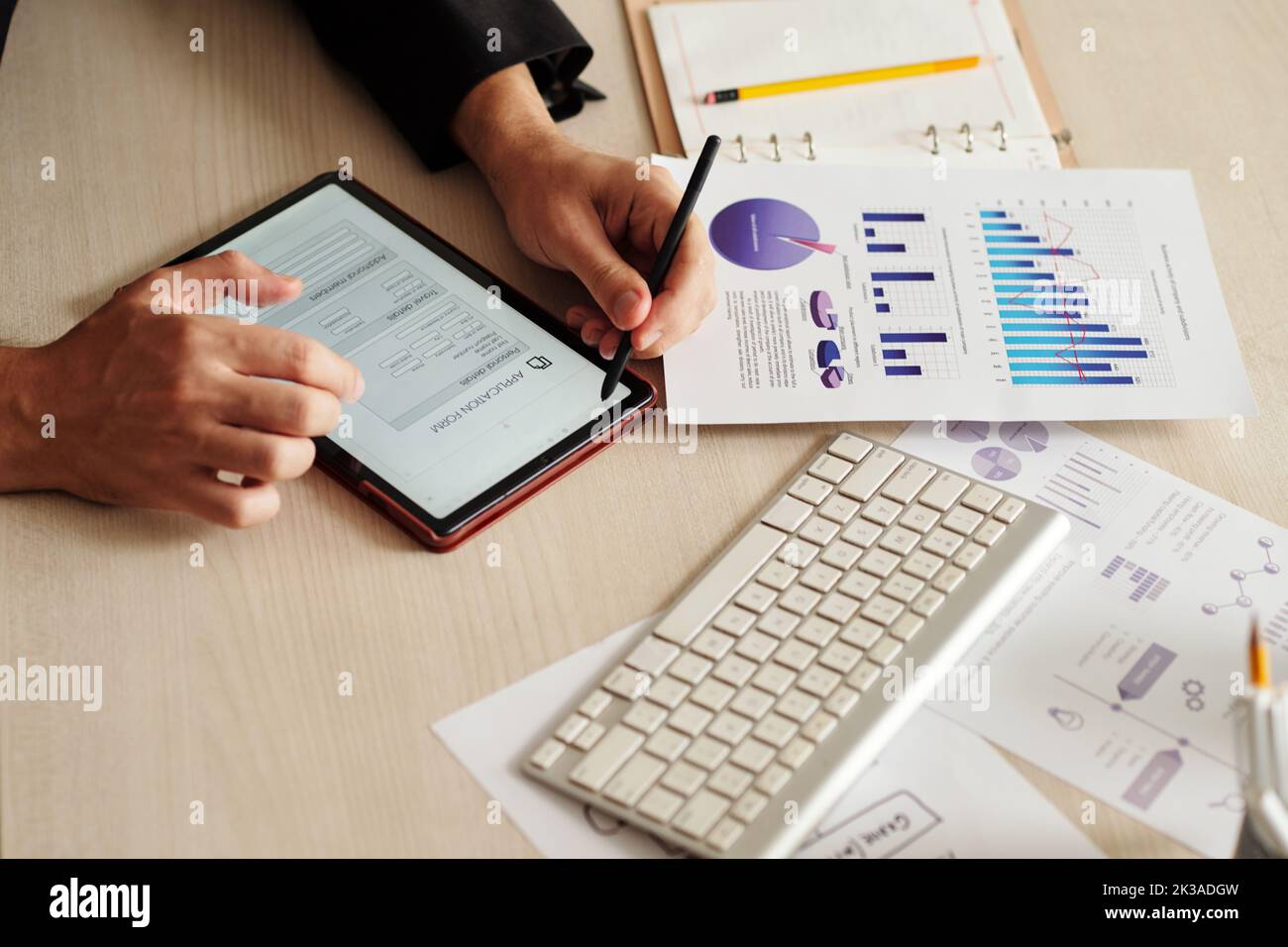 Hände des Geschäftsmannes, der mit Dokumenten arbeitet und das Antragsformular auf dem Tablet online ausfüllt Stockfoto