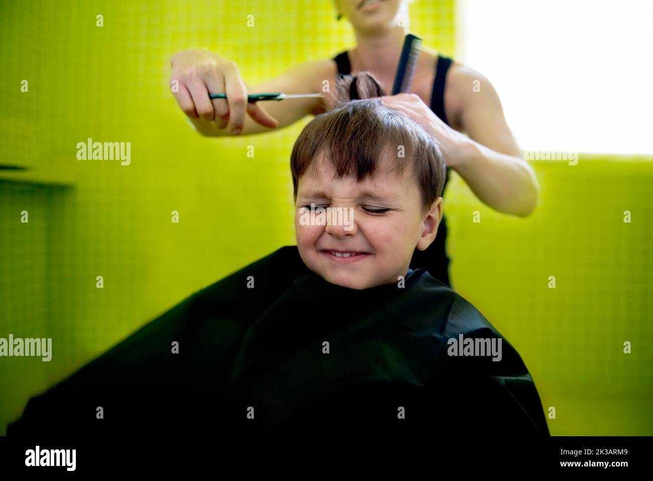 Dieser gefürchtete Haarschnitt im Schulalter... ein kleiner Junge bekommt seinen ersten Haarschnitt. Stockfoto