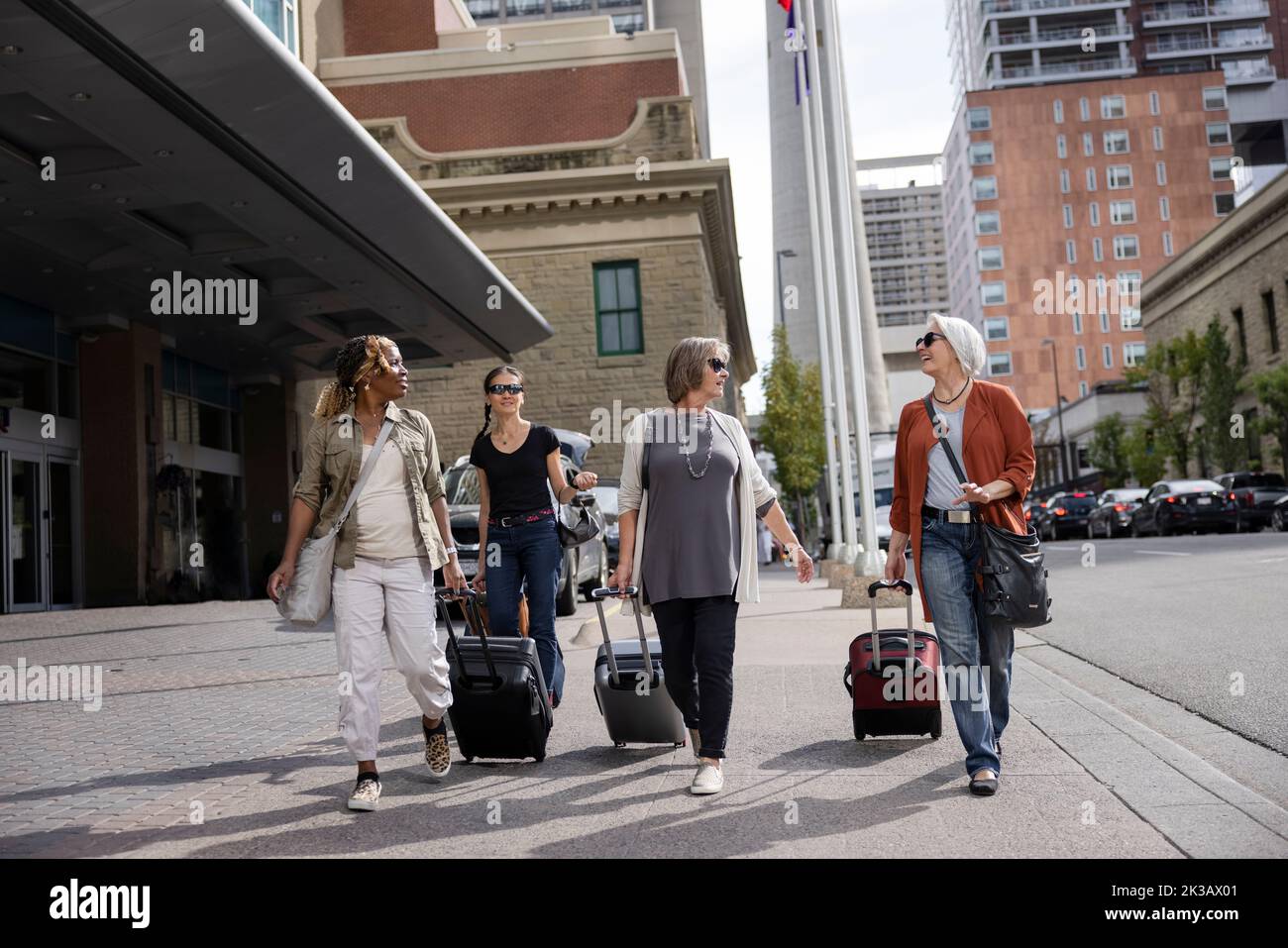 Reife Frauen, die mit Koffern in die Stadt reisen Stockfoto
