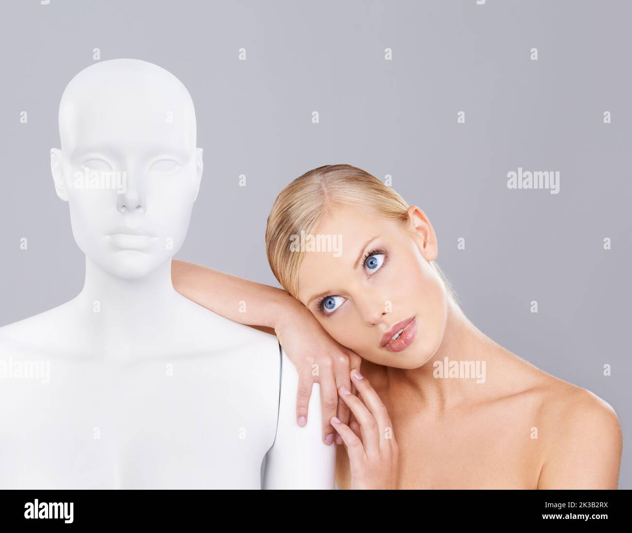 Wahre Schönheit geht es darum, ein Individuum zu sein... Eine schöne junge Frau, die neben einer Schaufensterpuppe steht. Stockfoto