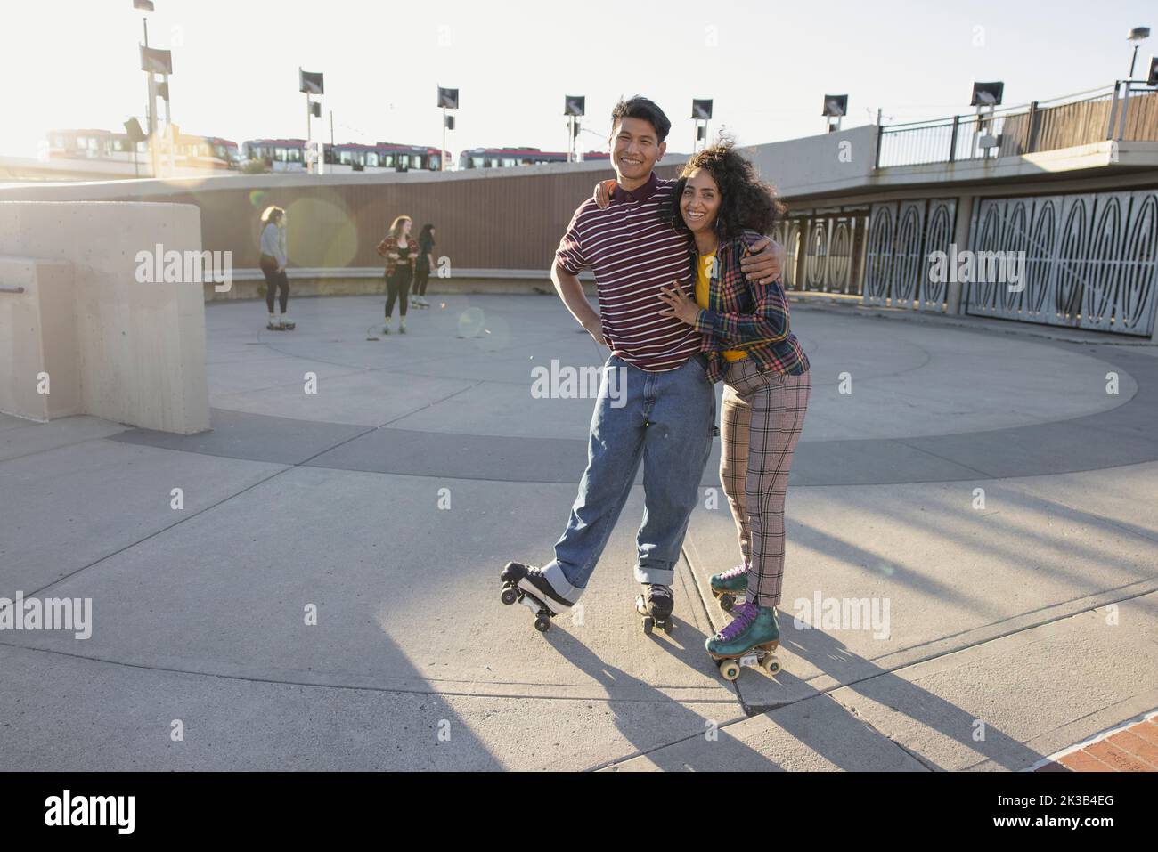 Portrait von multiethnischen Freunden, die sich auf Rollerskates umarmen Stockfoto