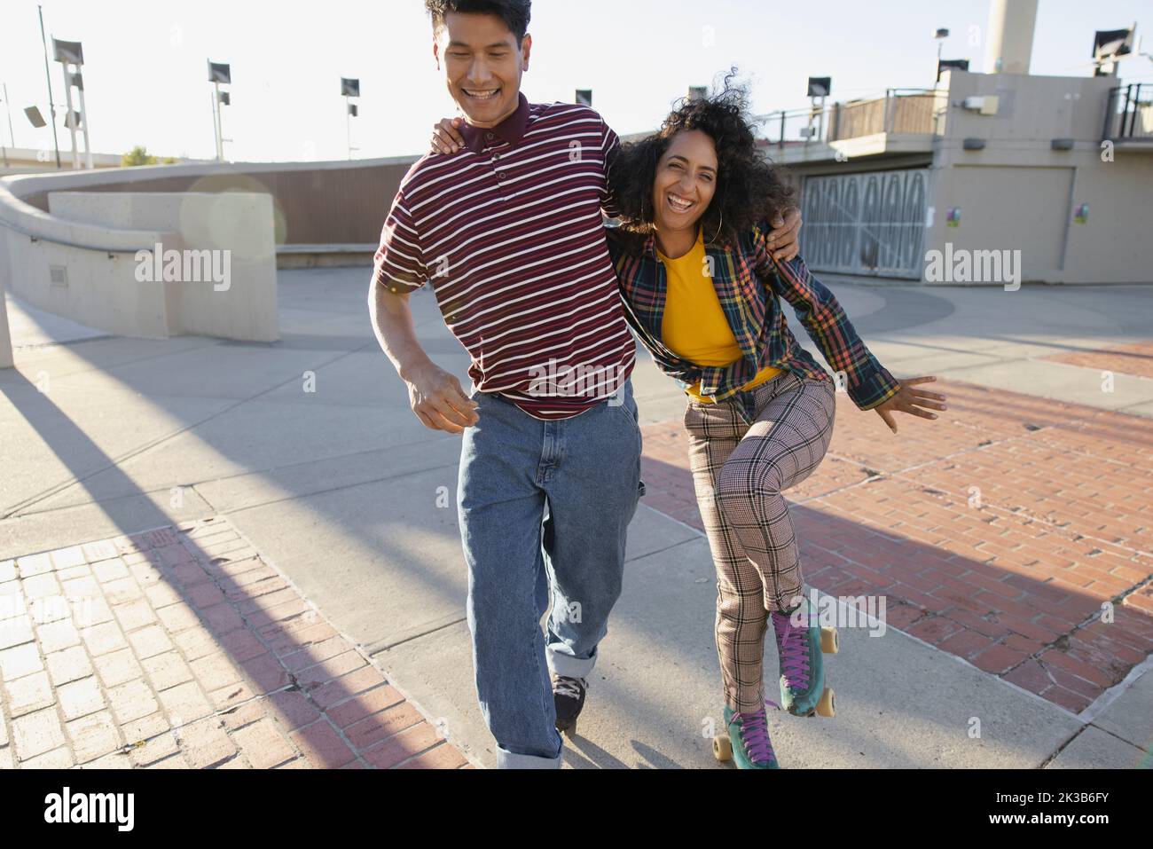 Portrait von multiethnischen Freunden, die sich auf Rollerskates umarmen Stockfoto