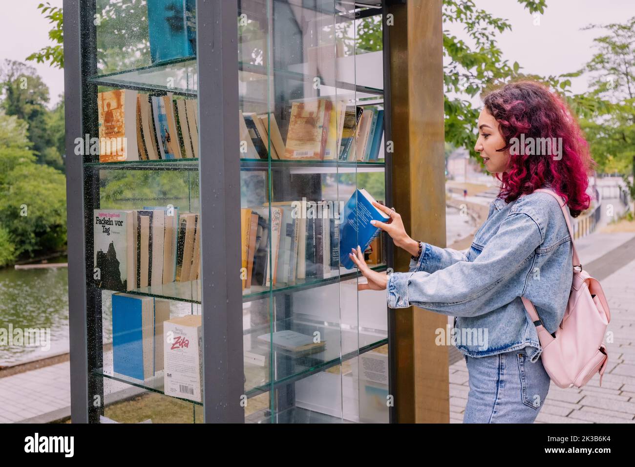 21. Juli 2022, Düsseldorf, Deutschland: Mädchen wählt Bücher in der freien öffentlichen Bibliothek im Stadtpark aus, um Bücher unter Lesern zu teilen. Stockfoto