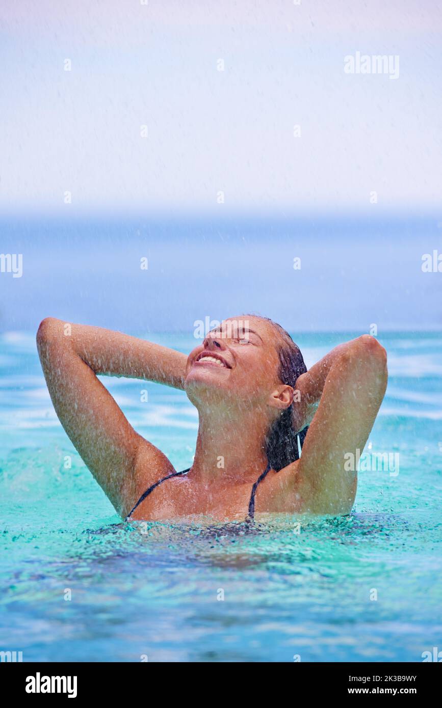 Eine entspannte Zeit im Wasser zu haben. Eine wunderschöne junge Frau, die im Schwimmbad steht. Stockfoto