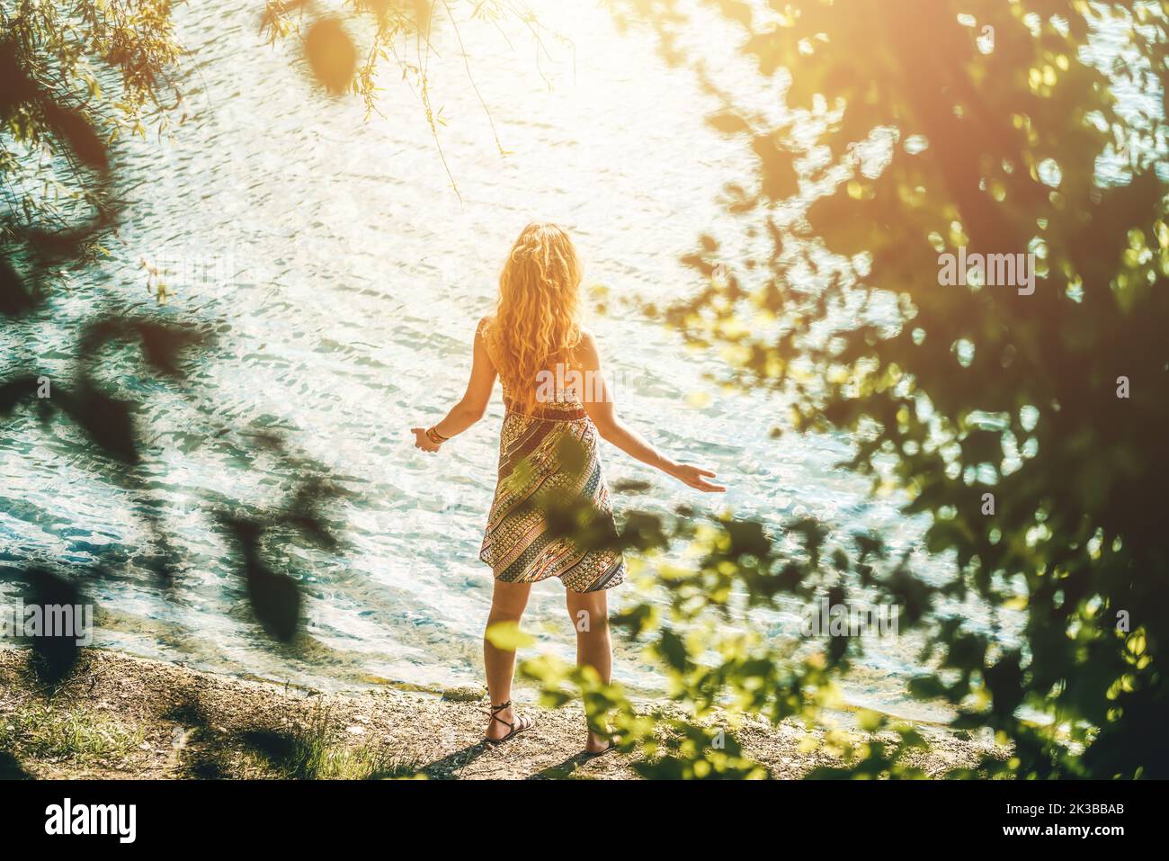 Junge schöne Frau, die am Wasser steht. Stockfoto
