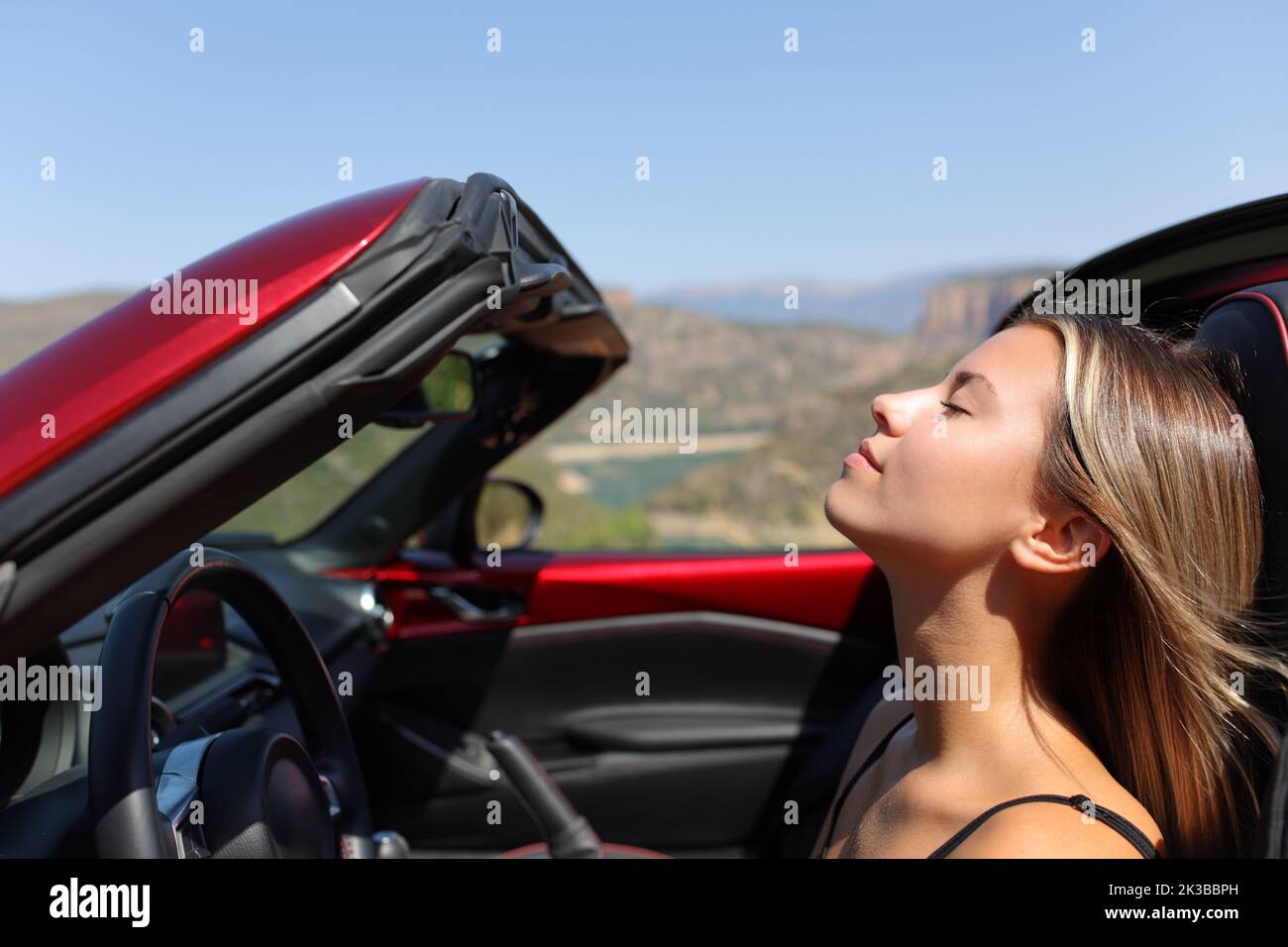 Entspannter Fahrer, der in einem Cabriolet frische Luft atmet Stockfoto
