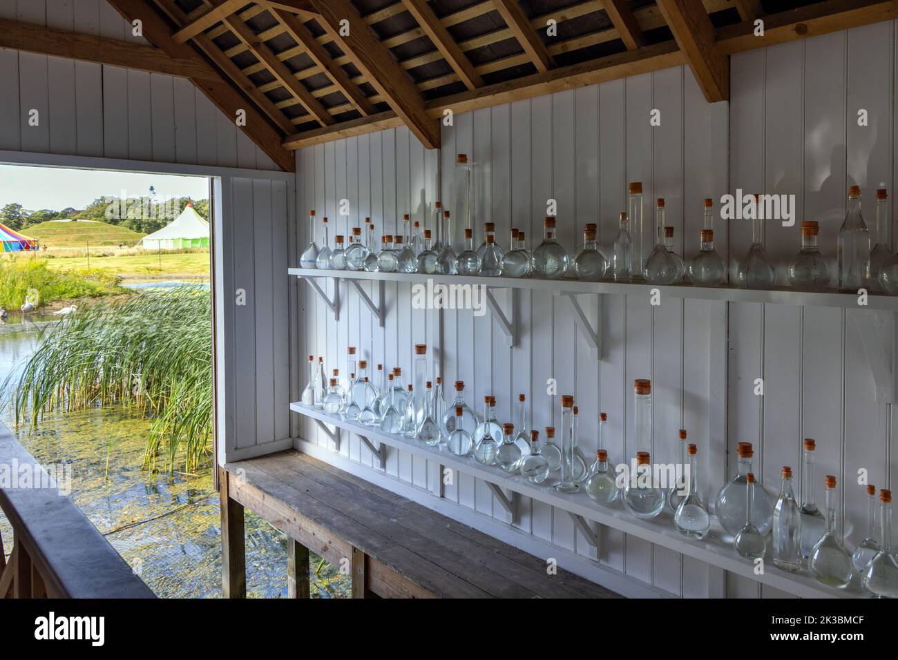 „Rivers“ von Tania Kovats enthält Wasserflaschen von 100 britischen Flüssen in einem Bootshaus auf dem Ententeich, Jupiter Artland, Wilkieston, Edinburgh. Stockfoto