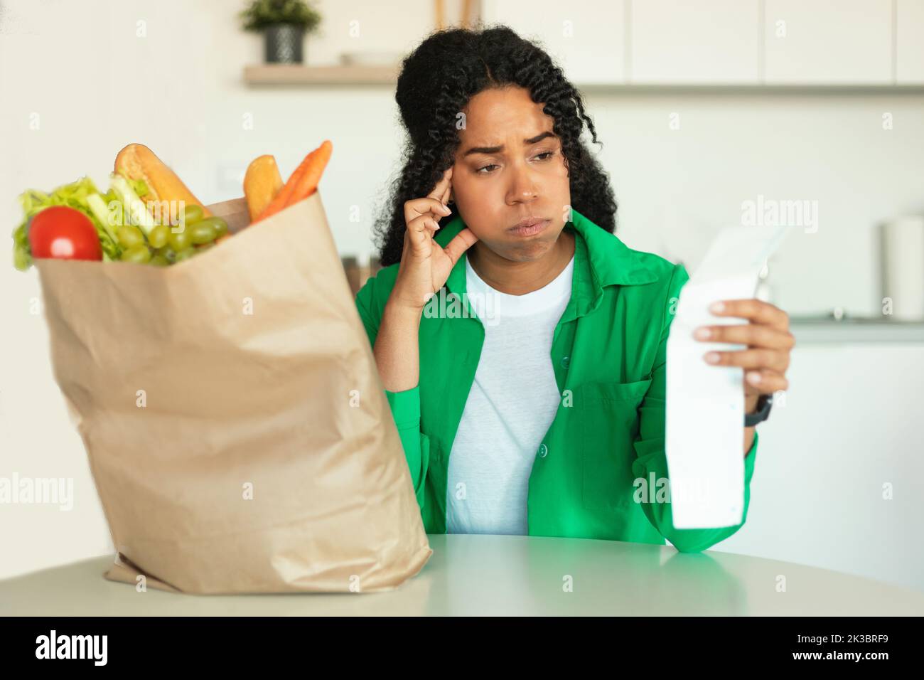 Unglückliche Afrikanische Frau, Die Bill Nach Dem Einkaufen Zu Hause Hält Stockfoto