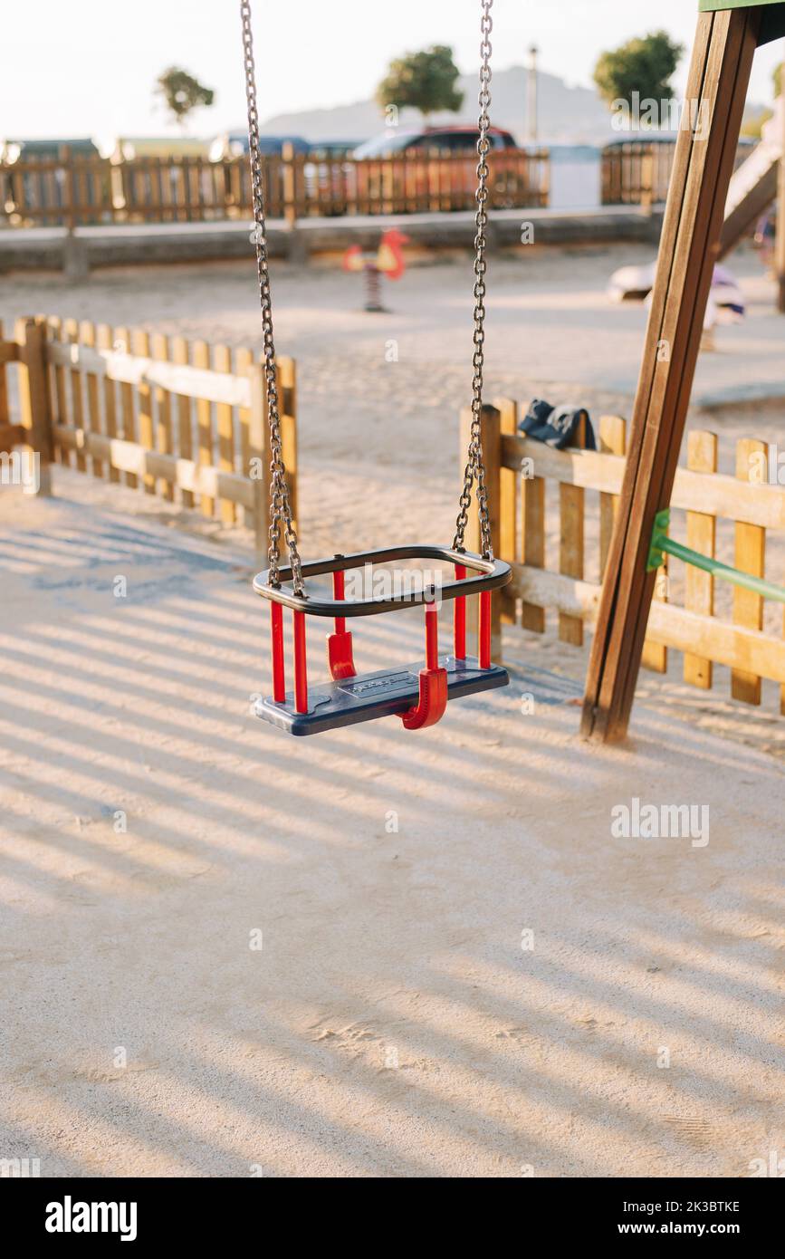 Detail einer Schaukel für Kleinkinder auf einem Kinderspielplatz bei Sonnenuntergang Stockfoto