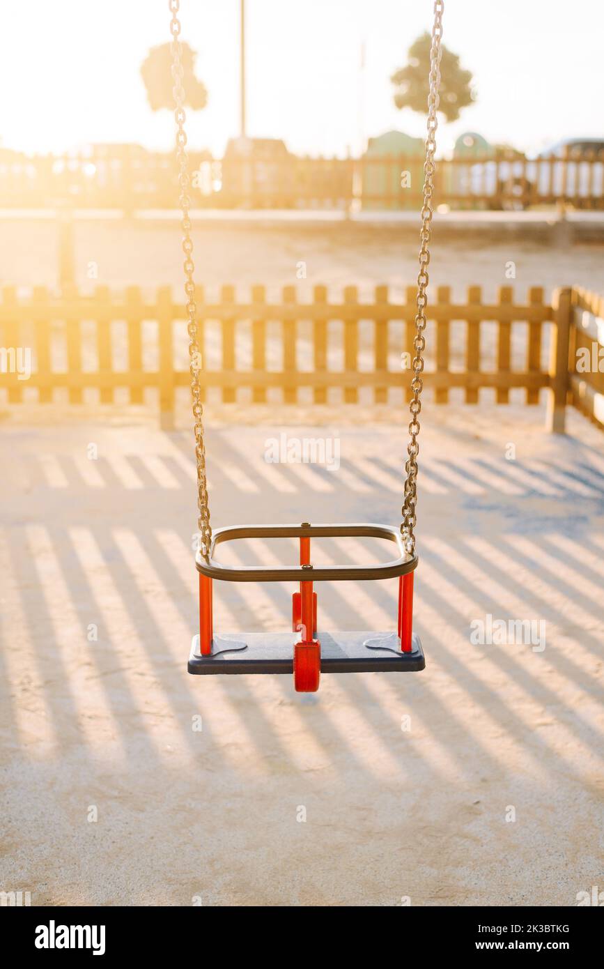 Detail einer Schaukel für Kleinkinder auf einem Kinderspielplatz bei Sonnenuntergang Stockfoto