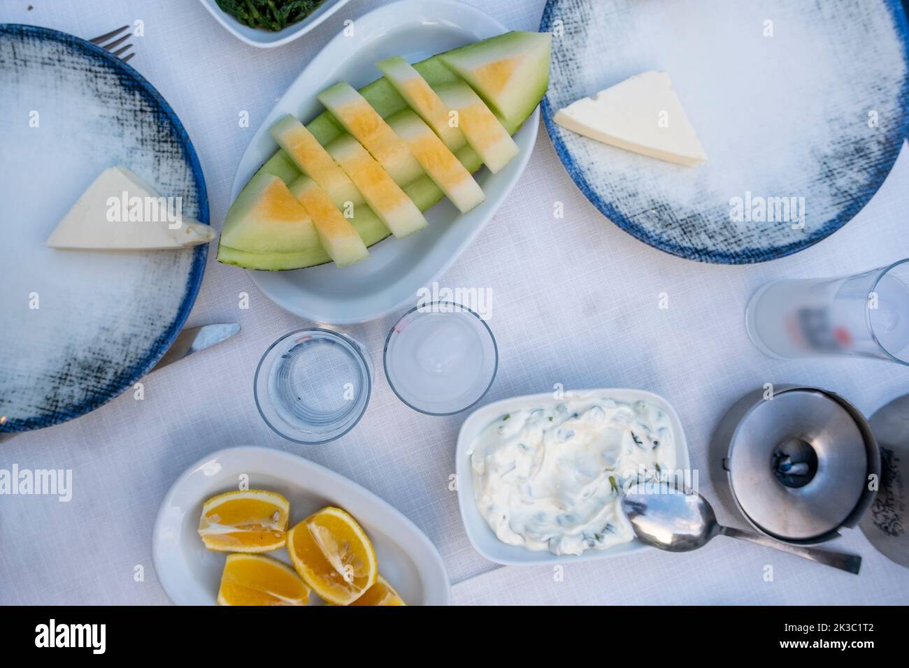 Traditioneller türkischer Alkohol, bekannt als Rakı, türkischer Raki-Tisch mit Melone, Zitrone und Vorspeise, chillen Sie mit Freunden im Restaurant, Abendessen und Speisenidee Stockfoto